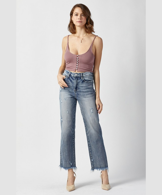Model wearing high rise straight leg light wash jeans with a distressed hem.